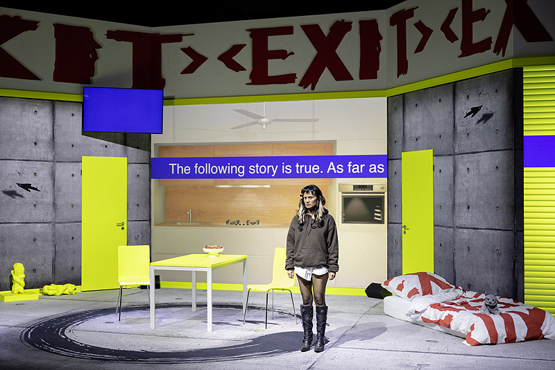 Angela (a strange loop) - representación teatral con personajes y un escenario con pantallas de video y colores fluorescentes