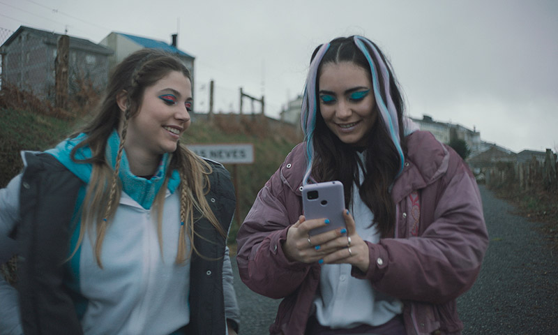 As Neves - fotograma de la película, se ve a dos chicas consultando un móvil