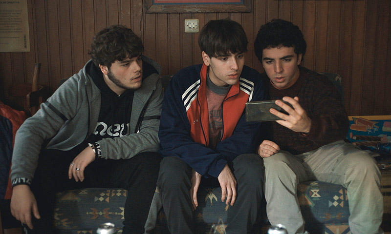 As Neves - fotograma de la película, se ve a tres chicos consultando un móvil