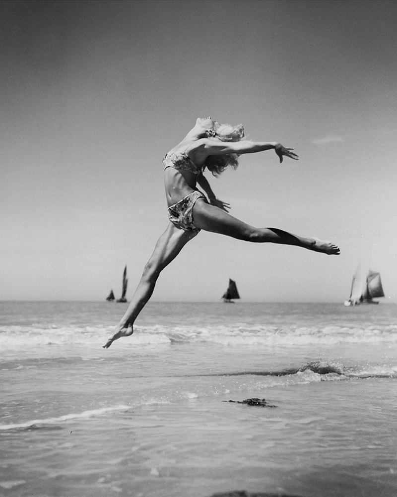 Fernand Fonssagrives - fotografía en blanco y negro de mujer dando un salto de ballet en una playa