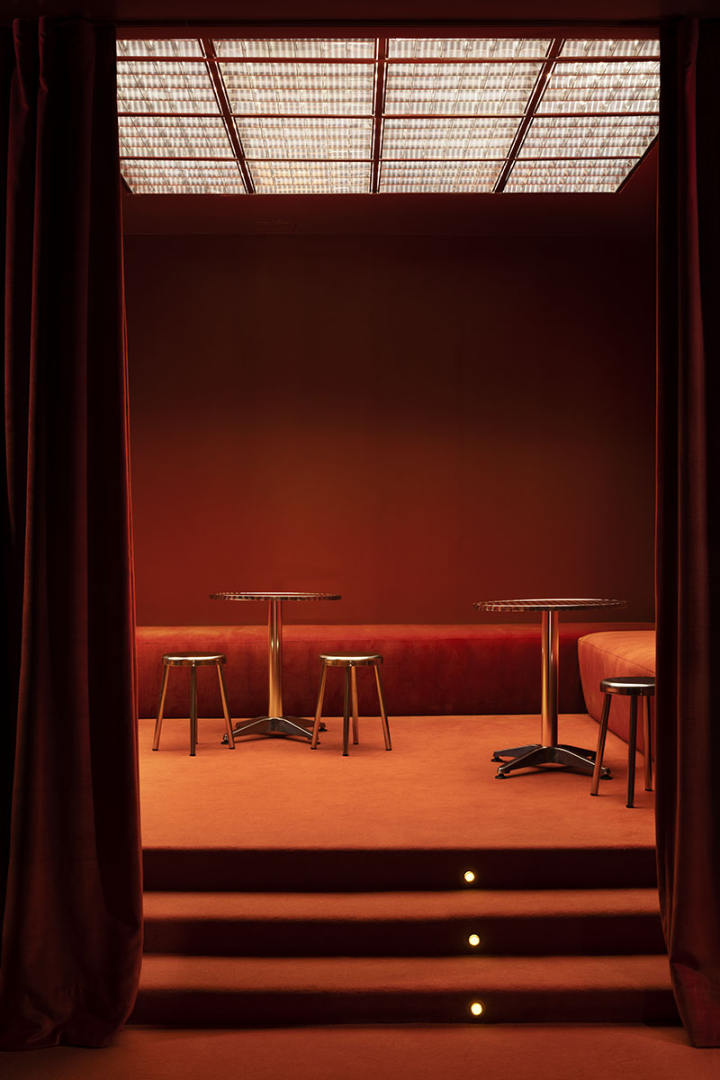 Gilda Haus Bar: una zona del local, suelo de moqueta naranja y un plafón de luminarias tipo oficina