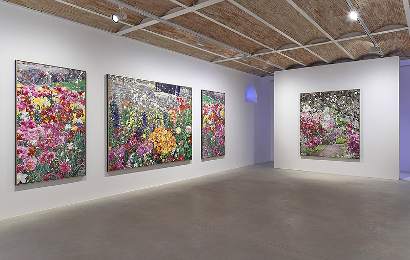 Damien Hirst. Vista de la exposición con cuadros de flores de colores.