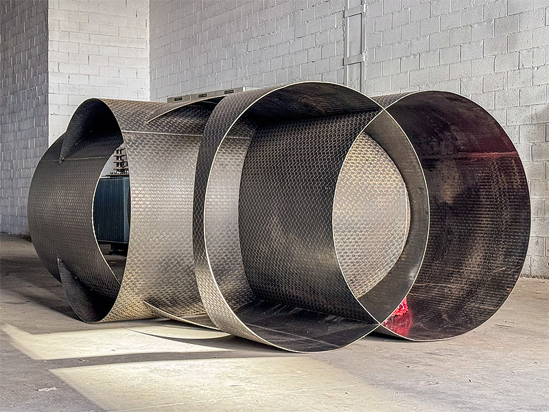 June Crespo. Imagen de instalación con cilindros de metal.