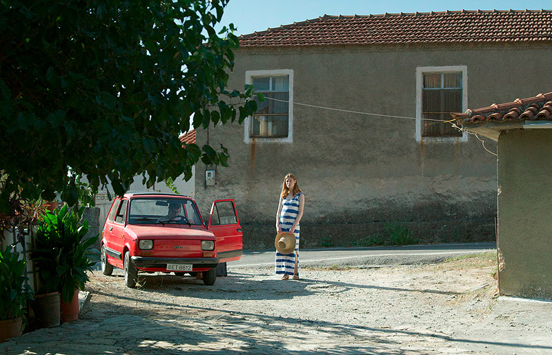 musica - imagen de una chica delante de una casa al lado de un coche rojo