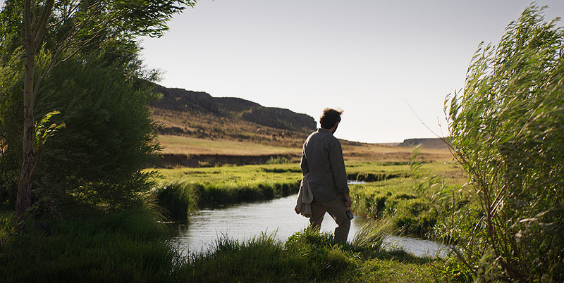 Sobre la hierba seca - fotograma de la película se ve a un hombre comtemplando un lago