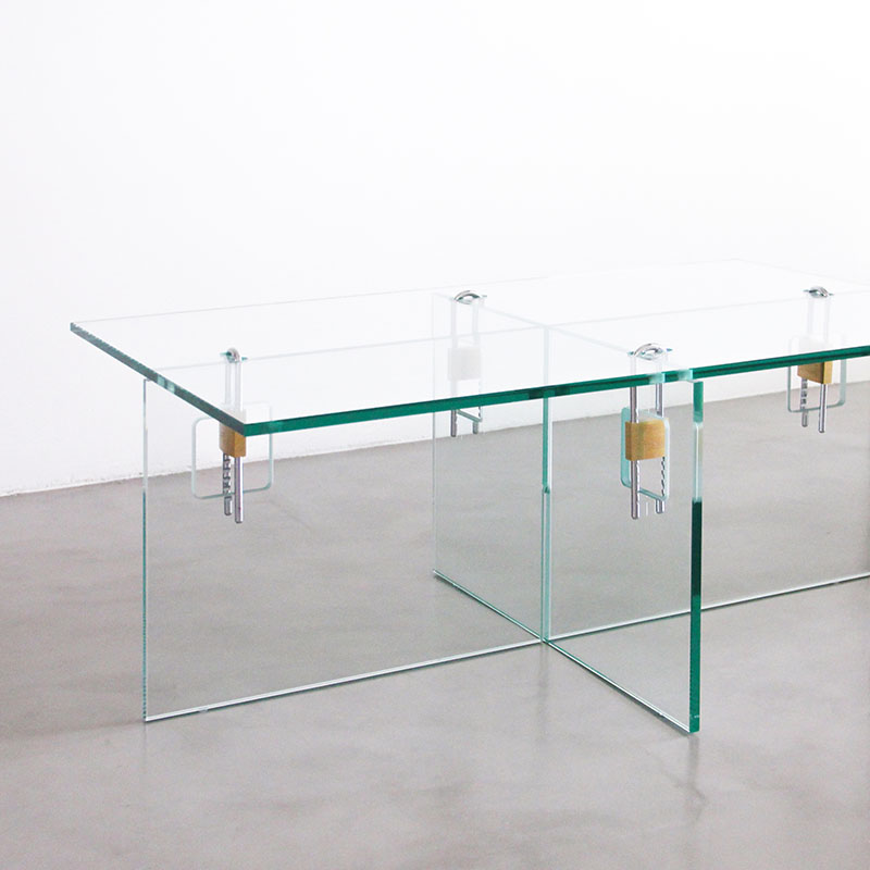 Estudio diseño Cuatro Cuatros: detalle de la mesa de vidrio 4E con candados