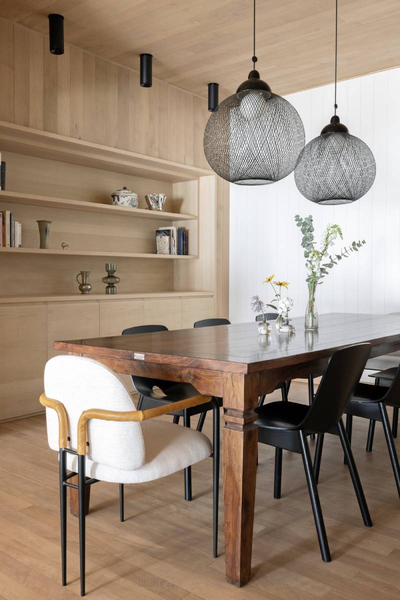 Imagine Mélodie Violet: Mesa con siete sillas, dos lamparas de diseño y una estanteria.