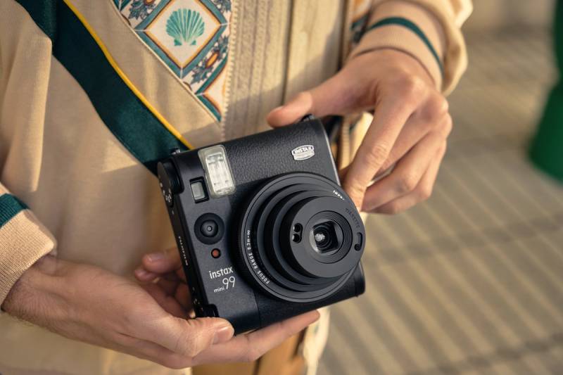 Instax Mini 99: un primer plano de una persona sosteniendo la cámara Instax Mini 99.
