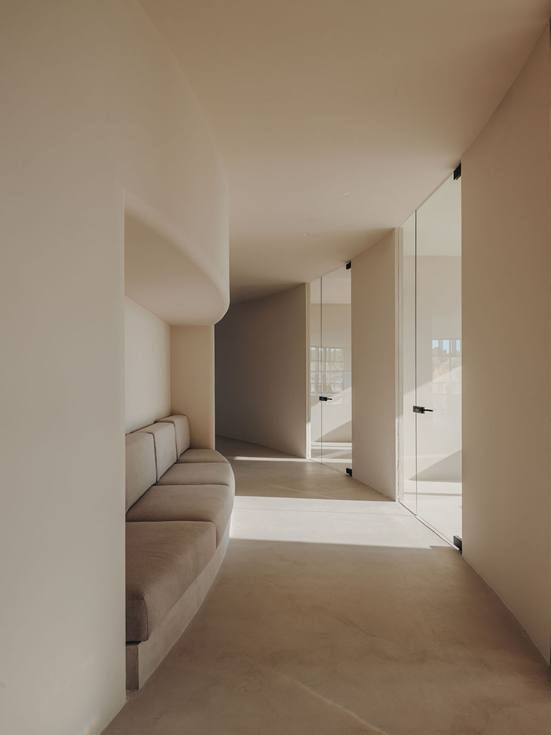 Isern Serra y Gigi Studios: el pasillo con un sofá empotrado en la pared