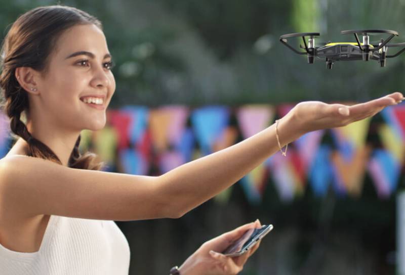 Mejores drones: una mujer jugando con el dron Ryze Tello.