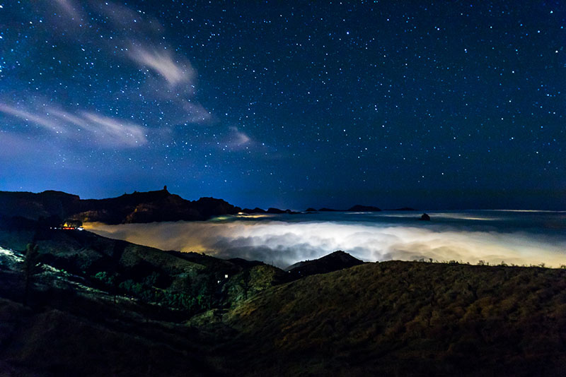 Planes nocturnos Paradores: un valle con nubes y el cielo estrellado