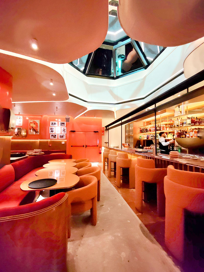 Restaurante Pabblo en Madrid: interiorismo del reservado con tonos naranjas y look a James Bond