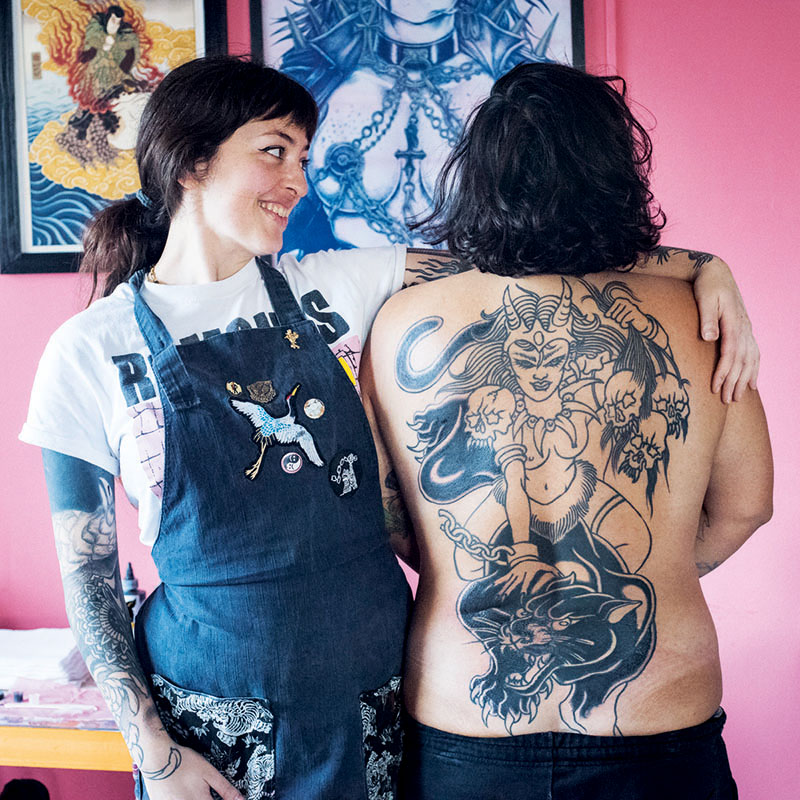 Tatuaje: Una Nueva Generación de Artistas: una artista junto a un hombre con la espalda tatuada