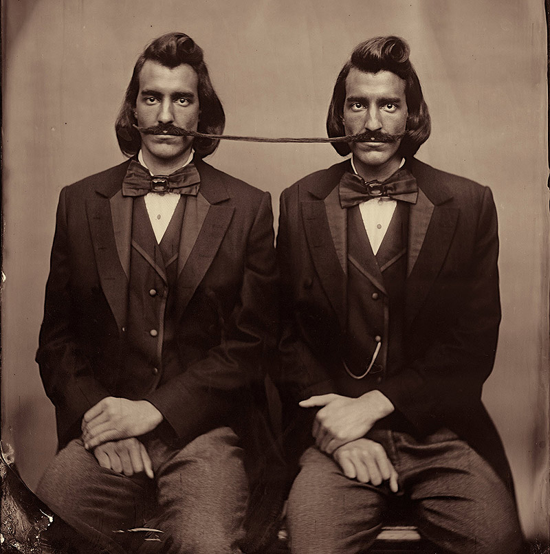 Smoke and Mirrors - imagen de una foto antigua, 2 señores unidos por el bigote