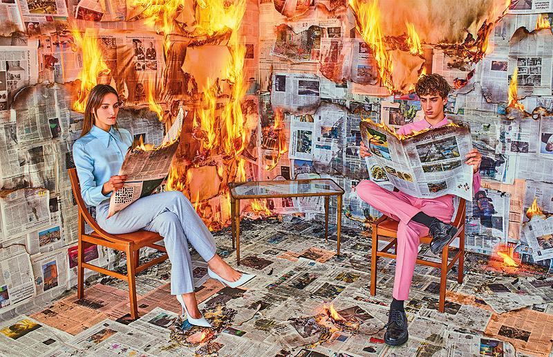 Toiletpaper - imagen de un hombre y una mujer leyendo el periodico dentro de un incendio
