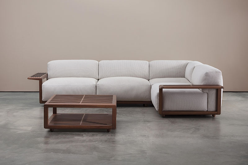 Andreu World novedades Milan Design Week 2024: sofá tapizado en tela gris junto a una mesita auxiliar