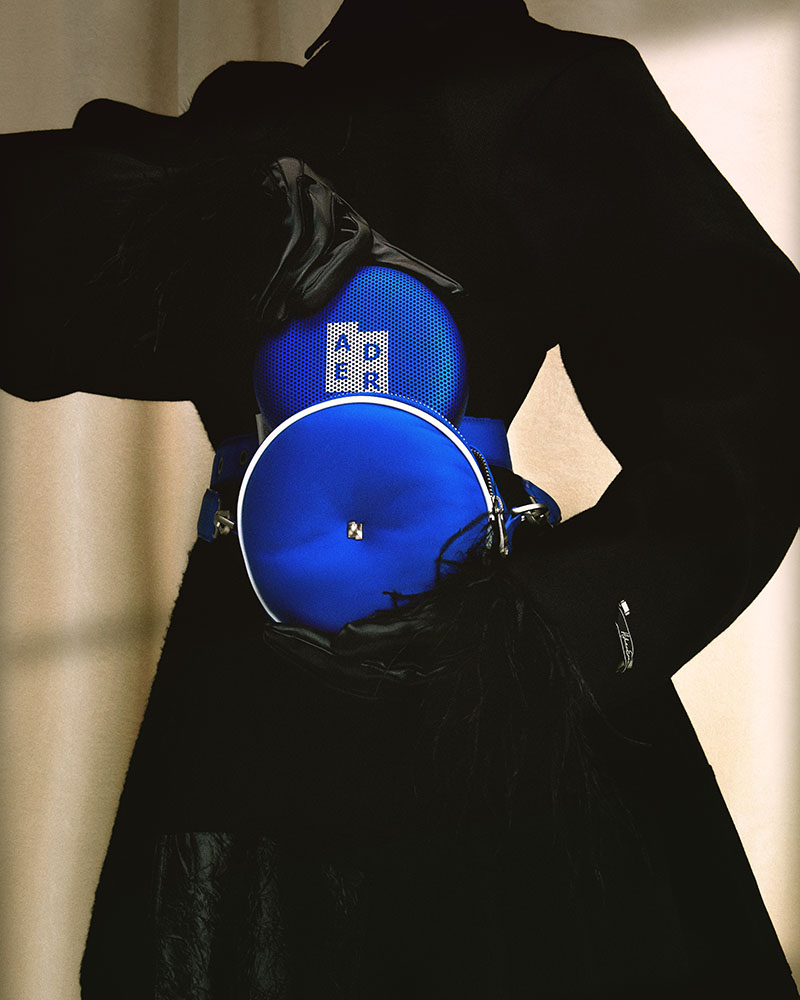Bang Olufsen Ader Error Beosoun A1: una mujer saca de su bolso azul un altavoz inalámbrico