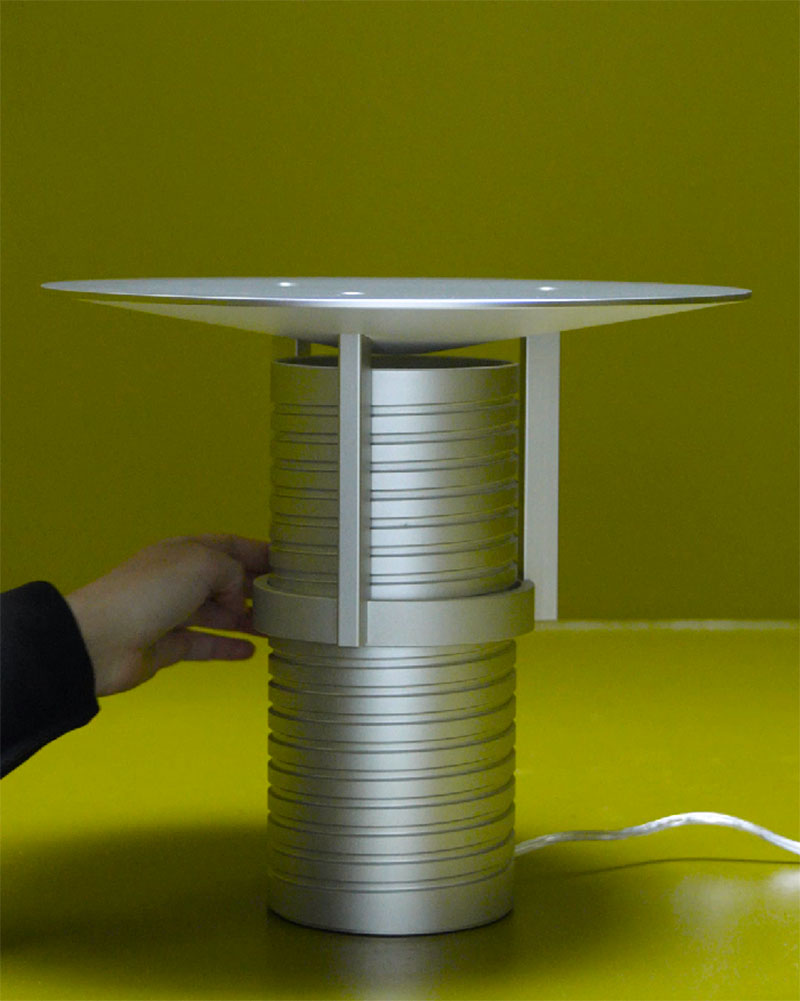 Muuto Set Lamp: la lámpara con forma de tornillo fabricada en aluminio sobre fondo verde