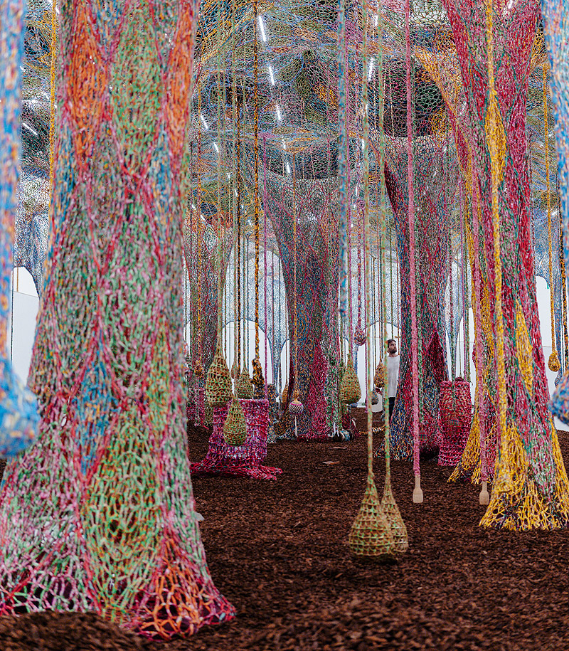Ernesto Neto. Imagen de la instalación con telas colgantes hechas de hilos de colores tomando todo el espacio.