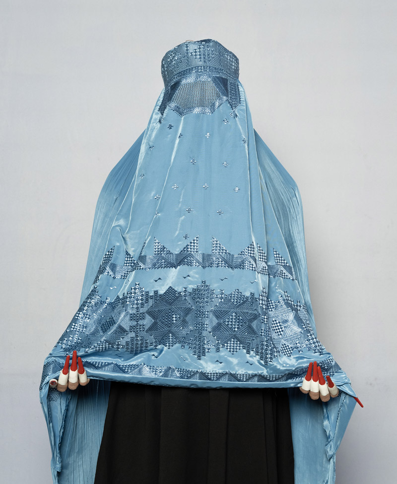 Revela't. Imagen de una mujer completamente cubierta por una tela azul.