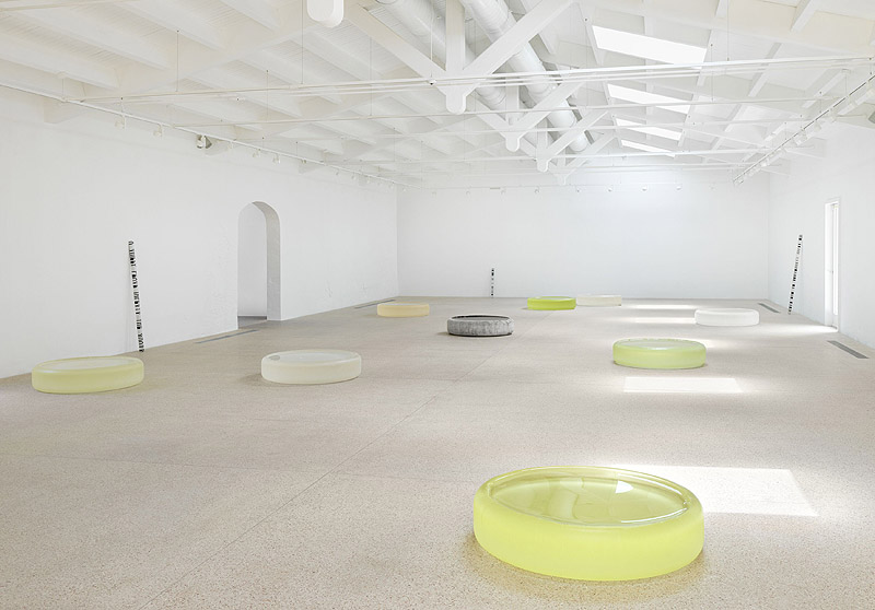 Roni Horn - vista de una exposición en una galería con esculturas de vidrio circulares de colores a modo de piscinas de niños
