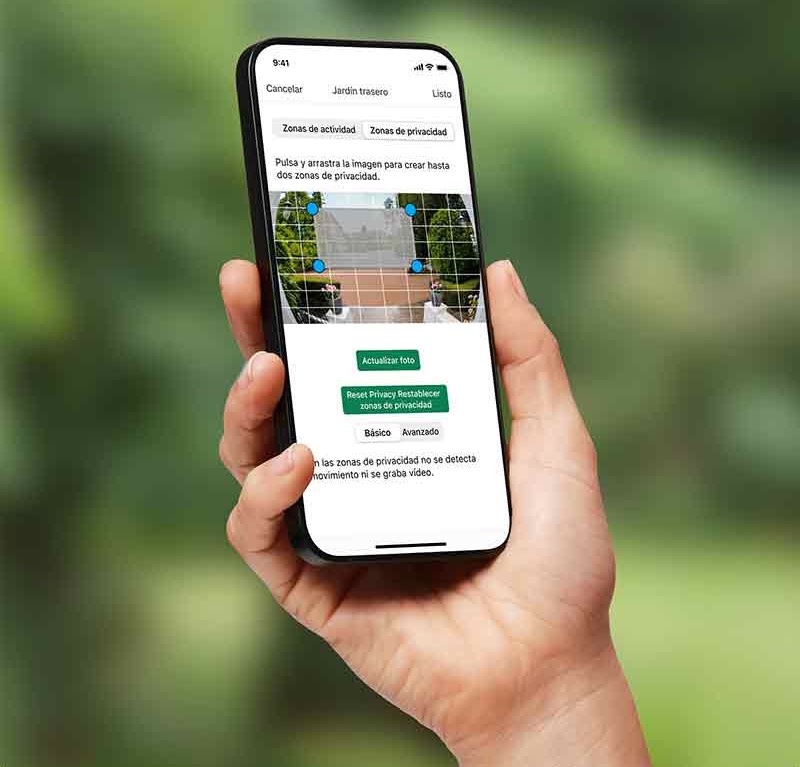 Blink Video Doorbell: la mano derecha de una persona de piel clara sostiene un smartphone que muestra la imagen de la cámara de Blink Video Doorbell ajustando el ángulo de la zona de privacidad.