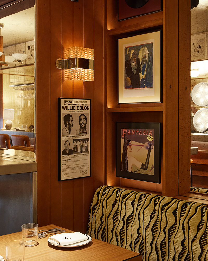 Casa Fiero dispone de un rincón con mesa, banqueta estampada y paredes decoradas con portadas musicales