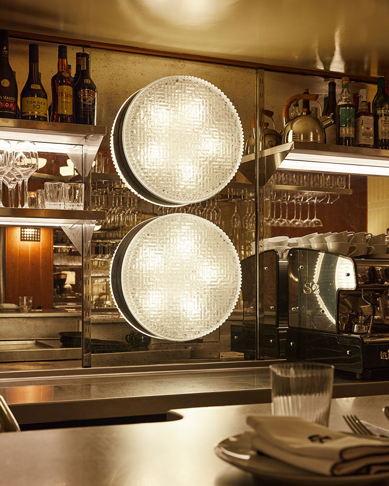 Casa Fiero incorpora lámparas circulares de cristal texturizado sobre la barra