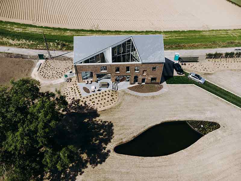Vista aérea de Casa Lyco, intervención de Oyo Architects sobre una estructura rural, con cubierta reformada y patio triangular