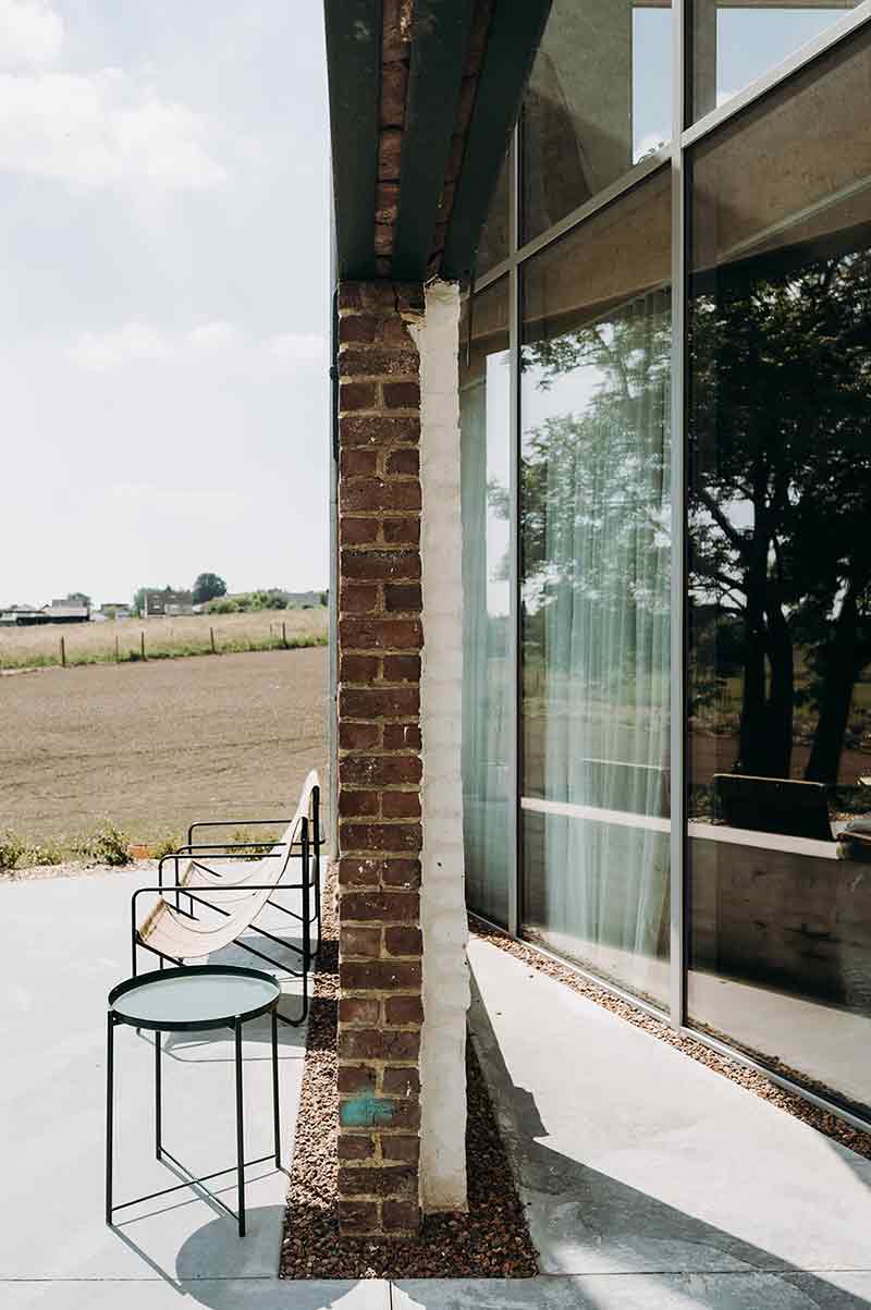 Detalle de la fachada de Casa Lyco, donde Oyo Architects conserva la textura original del ladrillo y lo vincula con nuevas superficies acristaladas