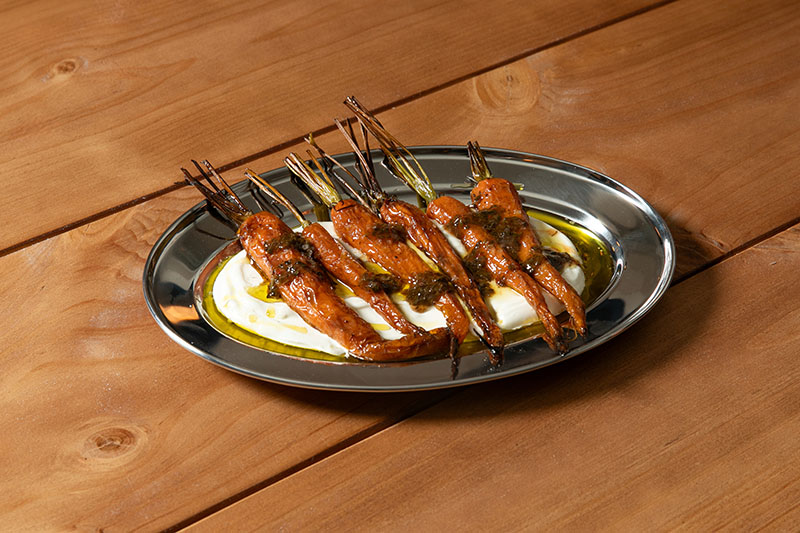 Zanahoria Baby Asada con chimichurri ahumado y base de queso ricotta, plato de La Diez, nuevo local de Madrid especializado en milanesas