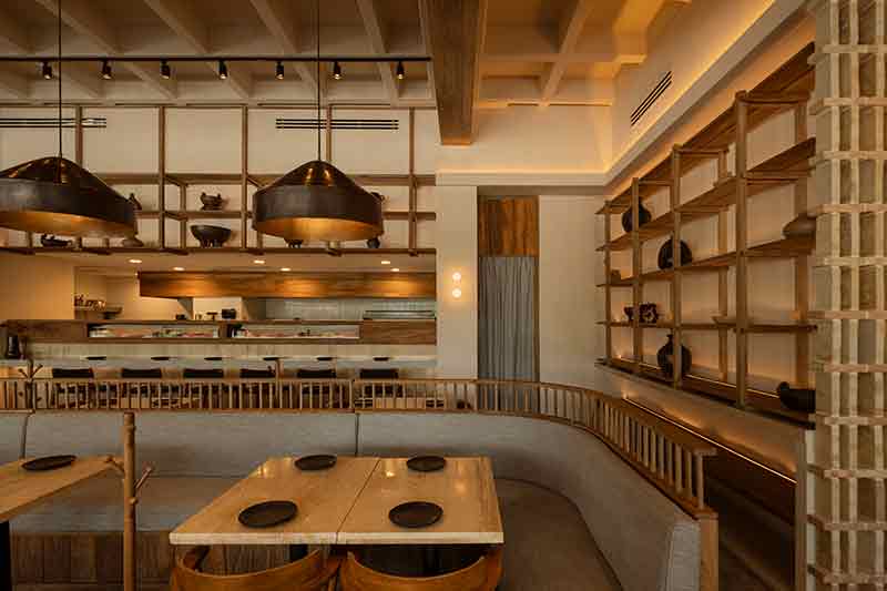 Área central de SC | Nido Cancún proyectada por Neutro Estudio con bancas perimetrales y lámparas colgantes