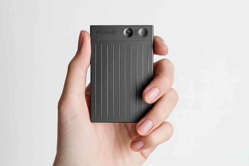 Plaud Note: primer plano de la mano de una mujer de piel clara que sostiene una grabadora Plaud Note en gris espacial sobre un fondo blanco.