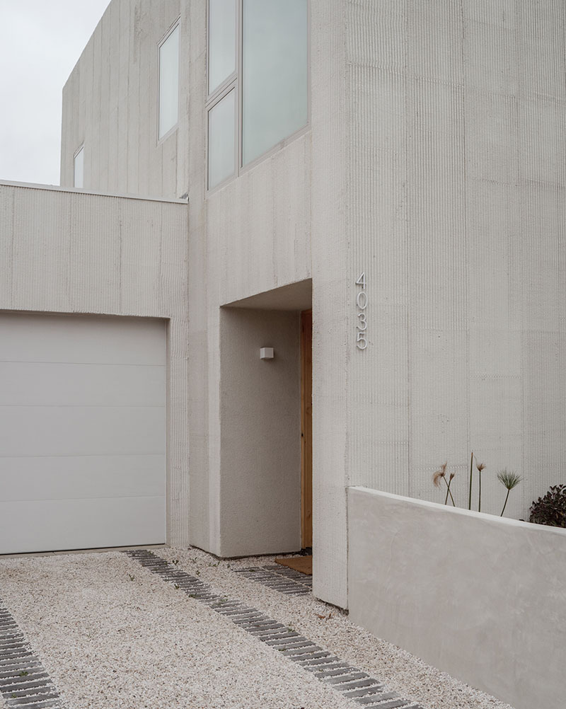 Mar Vista de PPAA resuelve la entrada principal con un acceso enmarcado en concreto estriado