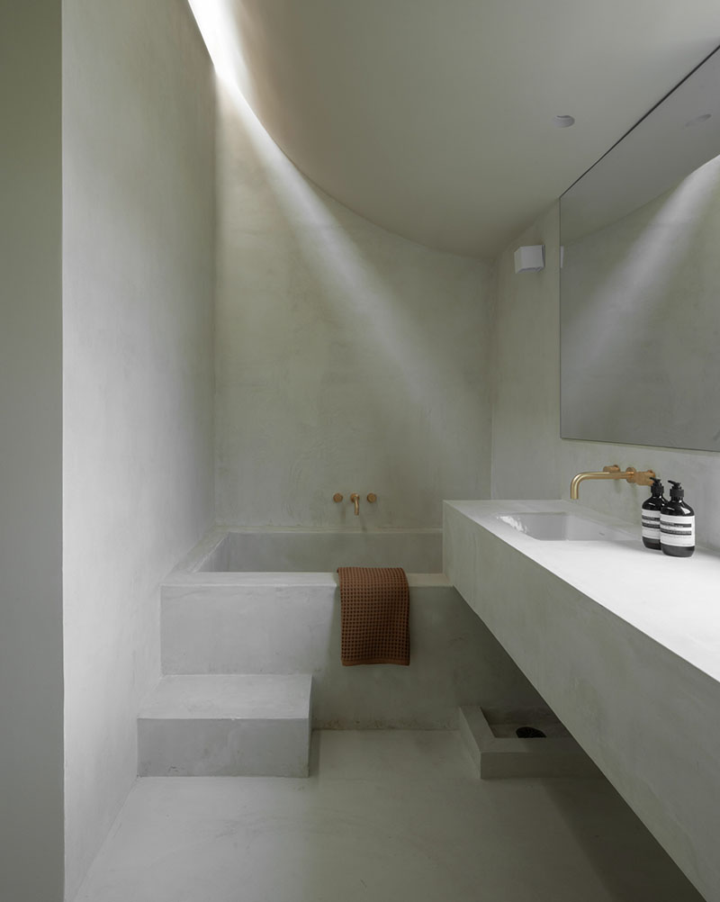 Mar Vista de PPAA ilumina el baño con un lucernario que dirige un haz de luz sobre el muro