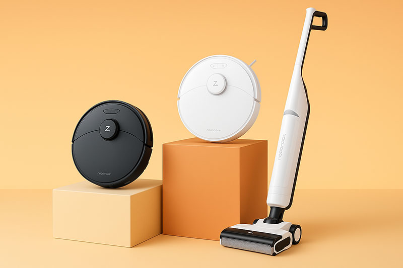 Roborock: en un fondo en fonos amarillos anaranjados hay tres aspiradores Roborock. De izquierda a derecha uno negro redondo sobre un escalón, uno blanco redondo sobre un cubo y uno alargado de palo sobre el suelo.