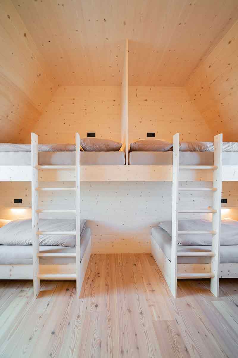 Dormitorio del Santnerpass con literas de madera y capacidad múltiple