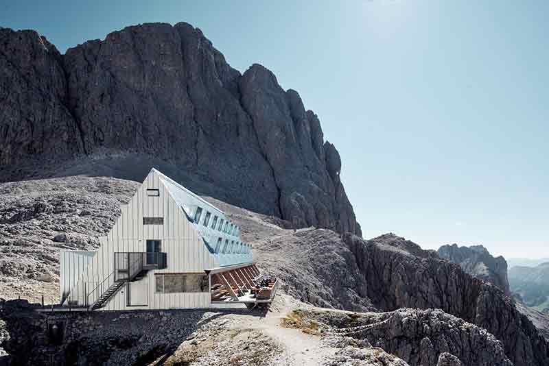 Vista lateral del Santnerpass con fachada metálica y escaleras exteriores frente a la roca