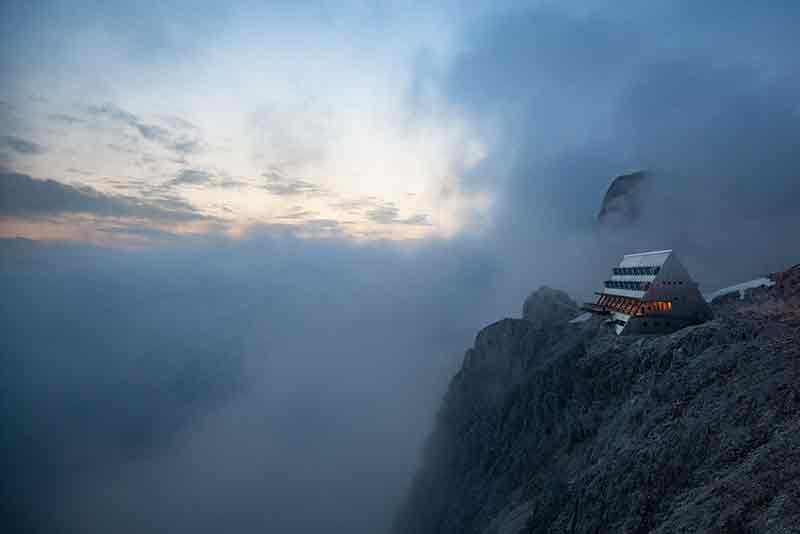 El Santnerpass iluminado entre la niebla al anochecer en el macizo Rosengarten