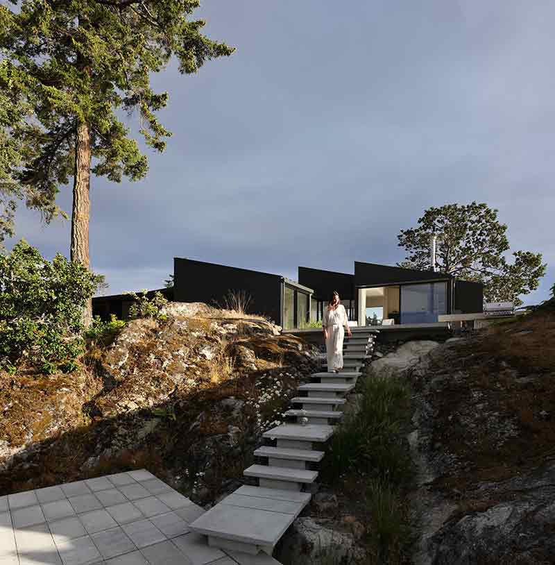 Shoreline House de Splyce Design conecta la vivienda con el terreno mediante una escalera exterior sobre la roca