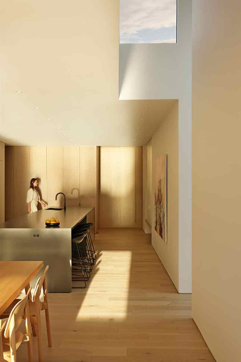 Shoreline House de Splyce Design articula la cocina y el comedor en un espacio continuo con luz cenital.