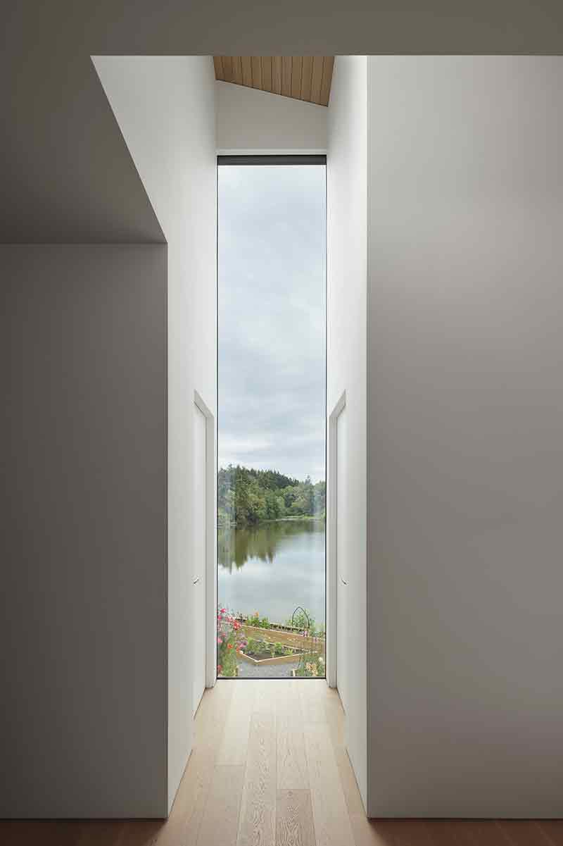 Shoreline House de Splyce Design enmarca el horizonte a través de un vano vertical de gran altura.