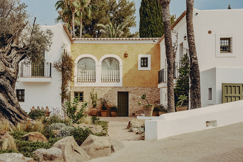 Soho Farmhouse Ibiza: fachada exterior de la finca con muro blanco y detalles en ocre