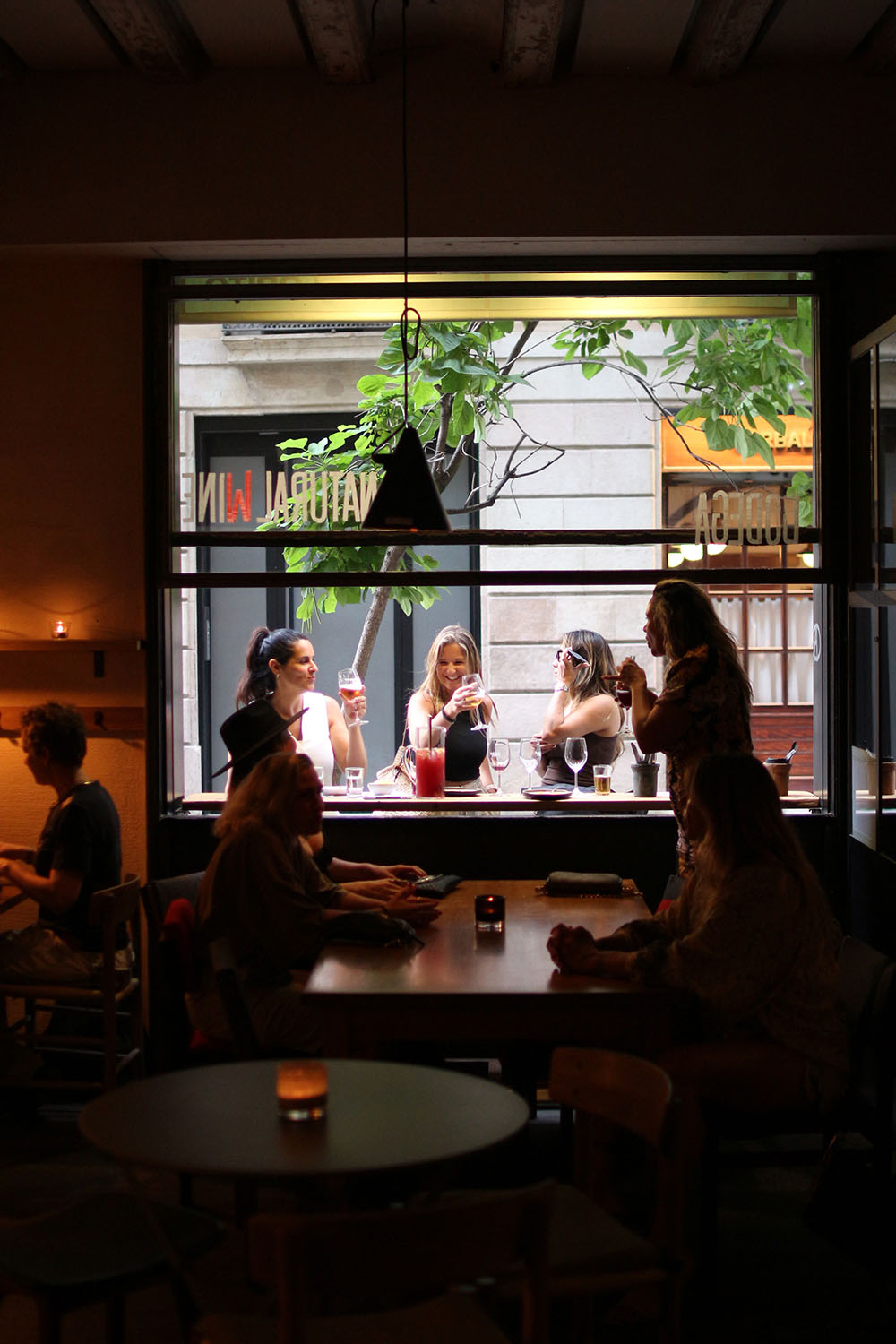 Interior con mesas y ventanales abiertos hacia la calle en Tapas Lobito Barcelona