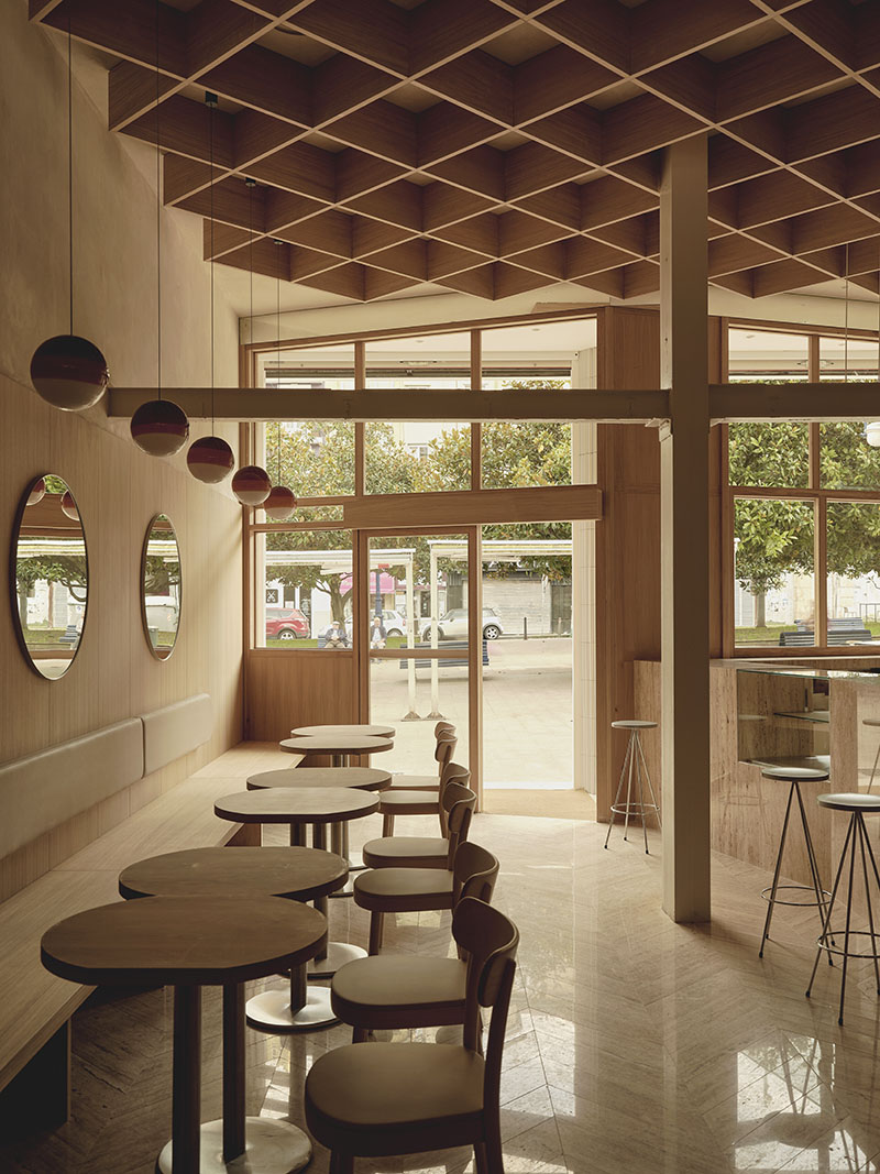 Acceso acristalado y área de mesas en la Heladería Regma diseñada por Zooco Estudio