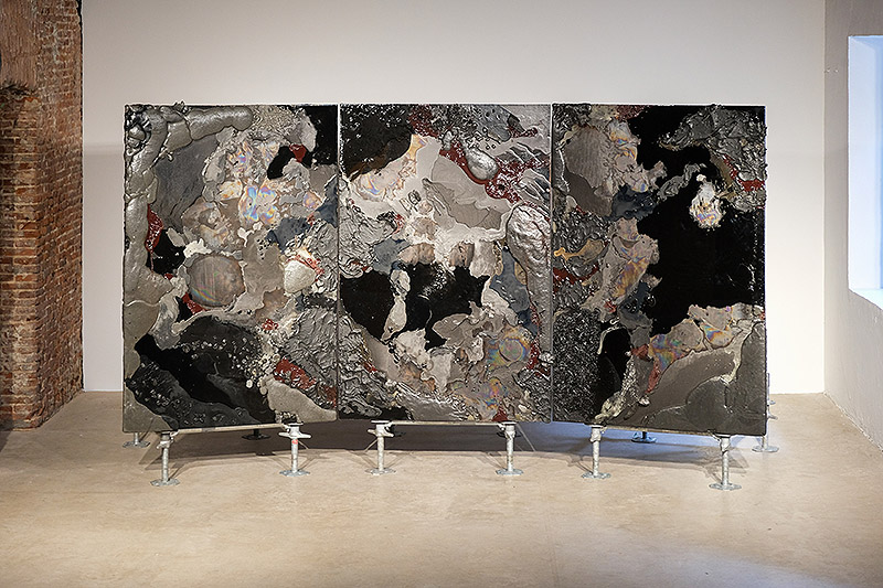 Vista de un tríptico con tonos oscuros hechos de carbón