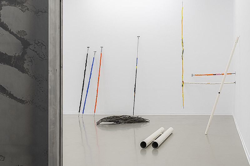 Oro tejido con Paja - vista de la exposición con esculturas por las paredes y el suelo