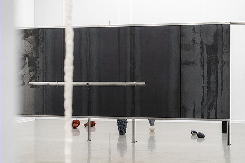 Oro tejido con Paja - vista de la exposición con esculturas por las paredes y el suelo