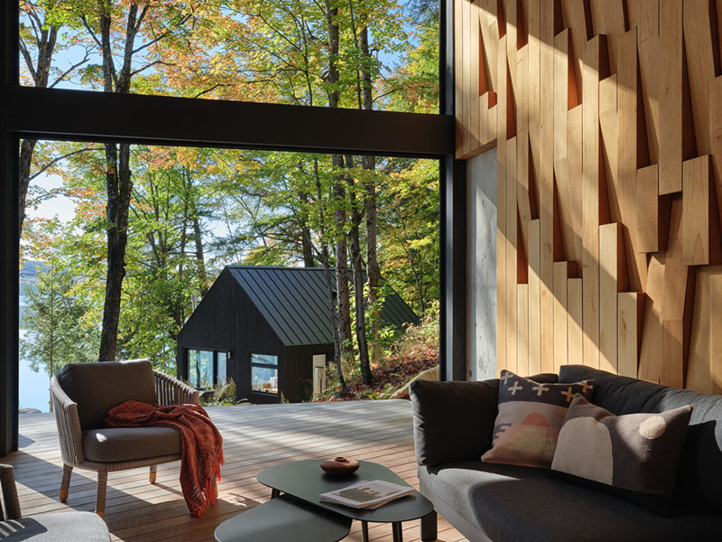 Interior de la sala de Barbora Vokac Taylor Architect con vista hacia el pabellón secundario junto al lago