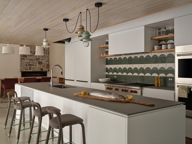 Cocina diseñada por Barbora Vokac Taylor Architect con isla central y revestimiento cerámico verde